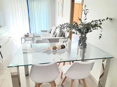 a living room with a glass table and white chairs at BEACH VALENCIA LUXURY D15-21 Apartment with terrace and sea views with two rooms in Valencia