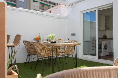 a patio with a table and chairs and a kitchen at SingularStays Plaza Andújar in Valencia