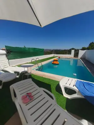 a view of a pool with chairs and a slide at Casa en la montaña con jacuzzi exterior y piscina in Alcántara de Júcar