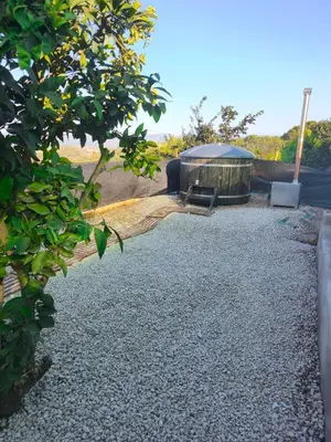 a garden with a building and a gravel driveway at Casa en la montaña con jacuzzi exterior y piscina in Alcántara de Júcar