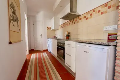 a kitchen with white cabinets and a stove top oven at Peaceful apartment in Peñalba in Peñalba