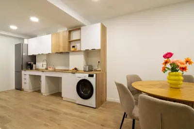 a kitchen with a washing machine and a table at Casa Pedro Cabanes in Valencia