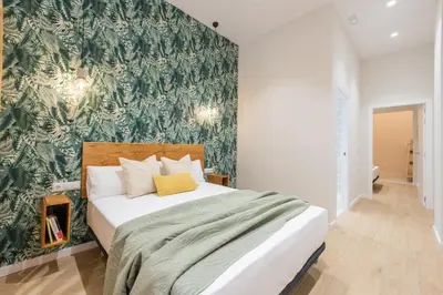 a bedroom with a bed with a green wallpaper at Marina Arts Lofts in Valencia