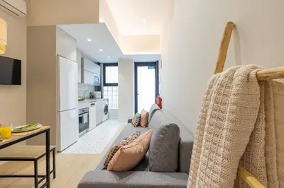a living room with a couch and a kitchen at Marina Arts Lofts in Valencia