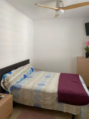 a bedroom with a bed and a ceiling fan at Encantador apartamento con terraza en la Playa de Moncófar in Moncófar