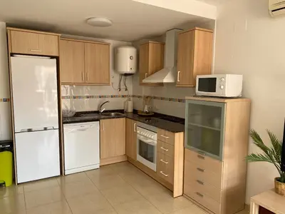 a kitchen with a white refrigerator and a microwave at Encantador apartamento con terraza en la Playa de Moncófar in Moncófar