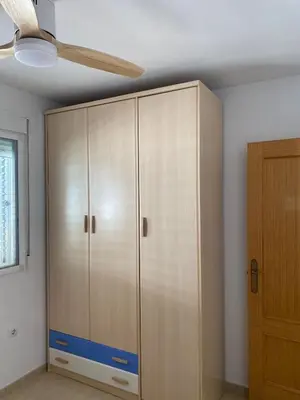 a large cabinet in a room with a ceiling fan at Encantador apartamento con terraza en la Playa de Moncófar in Moncófar