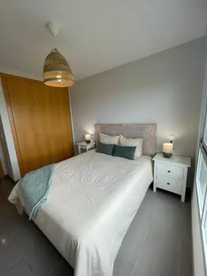 a bedroom with a large white bed and two night stands at kalma in Moncófar