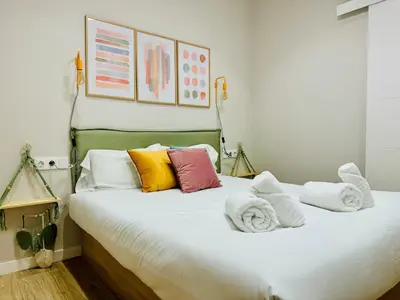 a bed with colorful pillows and towels on it at Modern Apartment with Style near Center in Valencia