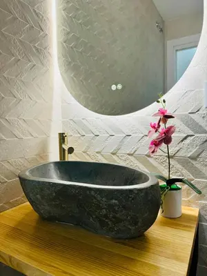 a bathroom with a black sink and a vase with a flower at Modern Apartment with Style near Center in Valencia