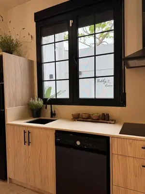 a kitchen with a black dishwasher under a window at The Robby's home in Valencia