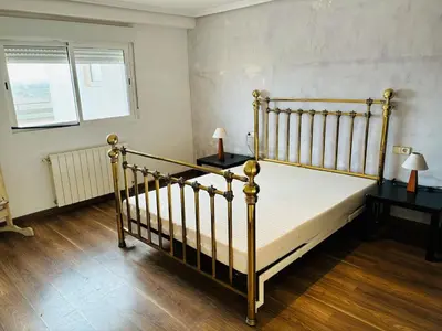 a bedroom with a bed with two night stands and two lamps at Atico con vistas al atardecer admitanse mascotas in El Puig