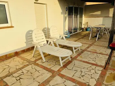 a group of white chairs sitting on a patio at Atico con vistas al atardecer admitanse mascotas in El Puig