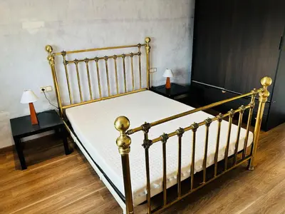 a bedroom with a bed with white sheets and two tables at Atico con vistas al atardecer admitanse mascotas in El Puig
