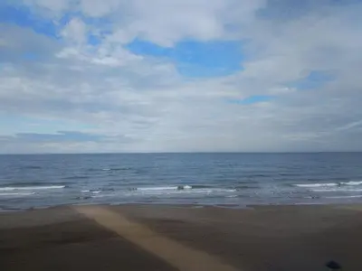 a beach with the ocean on a cloudy day at barlovento in Sueca