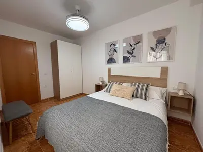 a bedroom with a large bed and some pictures on the wall at Magnifico apartamento de playa in Moncófar