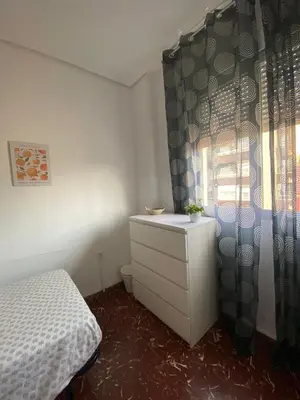 a bedroom with a bed and a dresser and a window at Rincón Valenciano - Campanar in Valencia