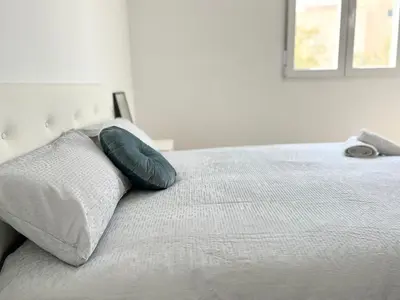 a bed with a blue pillow on top of it at El sitio de Ana in Burriana