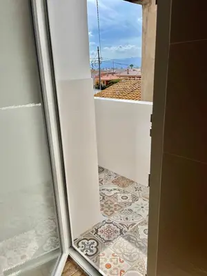 a bathroom with a glass door and a tile floor at El sitio de Ana in Burriana