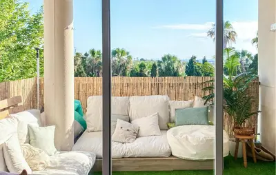 a white couch with pillows on a patio at Beach Front Apartment In Sagunto in Sagunto