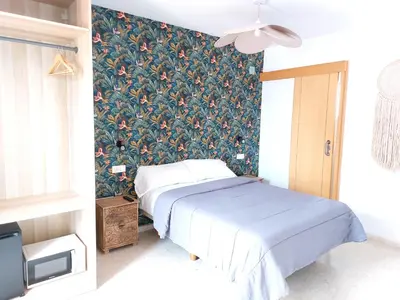 a bedroom with a bed with a floral wallpaper at ATTIC ROOMs VALENCIA in Valencia