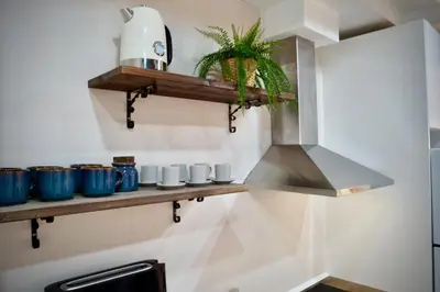 a kitchen with a shelf with cups and a stove at Dramaturgo Faust Hernandez Prime in Valencia