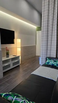 a room with two beds and a flat screen tv at Arena Legacy Modern Suits in Valencia