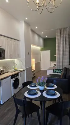 a kitchen and a living room with a table and chairs at Arena Legacy Modern Suits in Valencia