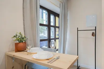 a table with two plates and wine glasses on it at Apartments LEON GABRIEL MIRÓ in Valencia