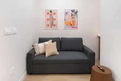 a blue couch in a living room with paintings at Apartments LEON PARE RICO in Valencia