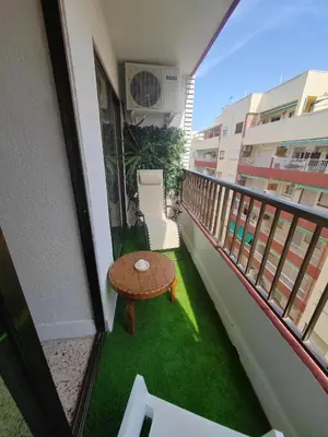 a balcony with a table and green grass at Au bord de la plage in Puerto de Sagunto