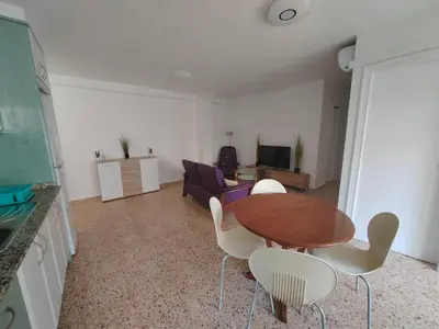 a living room with a table and chairs and a couch at Au bord de la plage in Puerto de Sagunto