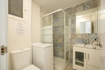 a white bathroom with a toilet and a shower at Apartamento Ciudad de las Ciencias con Terraza in Valencia