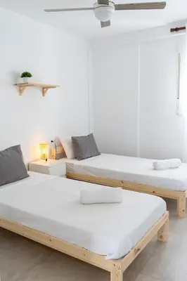 two beds in a room with white walls at Apartamento Ciudad de las Ciencias con Terraza in Valencia