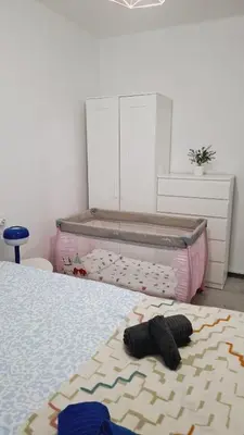 a bedroom with a bed with a crib and a rug at 3 bedroom apartment with a terrace 50 steps from the Nules beach in Mascarell