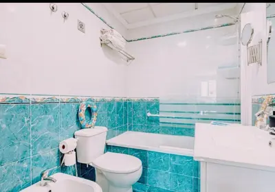 a blue tiled bathroom with a toilet and a sink at TODO INCLUIDO - Wifi,playa,piscina 24h,garaje,terraza y Mercadona -MUY CÓMODO in Canet de Berenguer