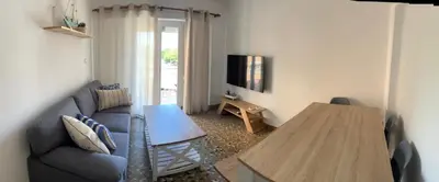 a living room with a blue couch and a wooden table at District Key - Puerto de Sagunto, Asturias in Puerto de Sagunto