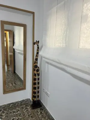 a giraffe standing on the wall next to a mirror at District Key - Puerto de Sagunto, Asturias in Puerto de Sagunto