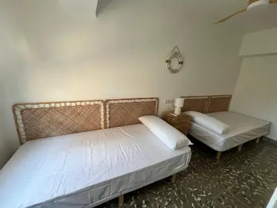 a bedroom with two twin beds and a chair at District Key - Puerto de Sagunto, Asturias in Puerto de Sagunto
