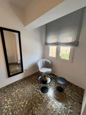 a living room with a chair and a table and a mirror at District Key - Puerto de Sagunto, Asturias in Puerto de Sagunto