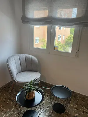 a living room with two tables and a chair and a window at District Key - Puerto de Sagunto, Asturias in Puerto de Sagunto