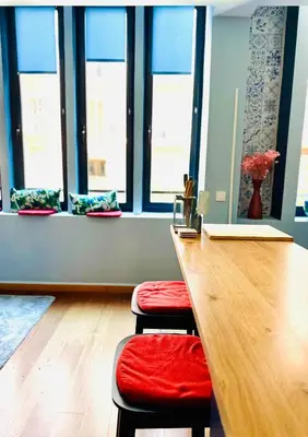 a room with a long table with stools and windows at Trendy Ruzafa Neighborhood - Spacious Luxury 3BR with Double Terrace in Valencia