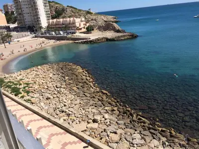 a beach with a group of people on the water at Fantásticas vistas al mar en el Faro in Faro de Cullera