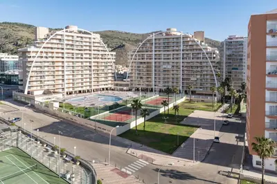 two large buildings in a city with palm trees at El Raco, C-5-10 in Cullera