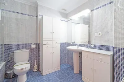 a bathroom with a toilet and a sink and a mirror at Global Vacacional, Apartamento con terraza en la playa de Puerto Sagunto in Puerto de Sagunto