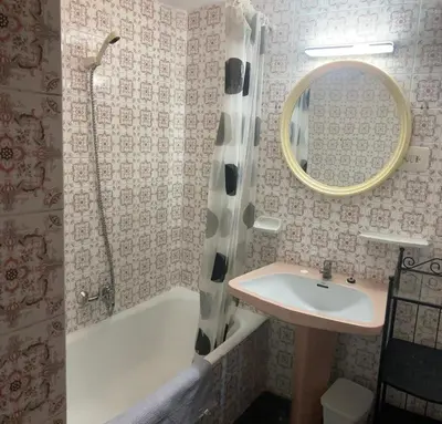 a bathroom with a sink and a tub and a mirror at Résidence El Prado in Cullera