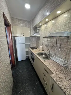 a small kitchen with a sink and a refrigerator at Résidence El Prado in Cullera