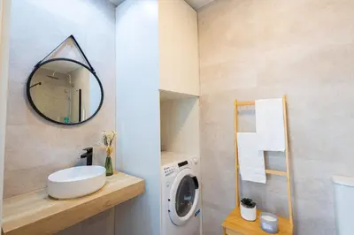 a bathroom with a washing machine and a mirror at GuestReady - Inviting Valencia retreat in Valencia