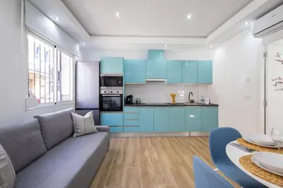 a kitchen with blue cabinets and a gray couch at GuestReady - Inviting Valencia retreat in Valencia