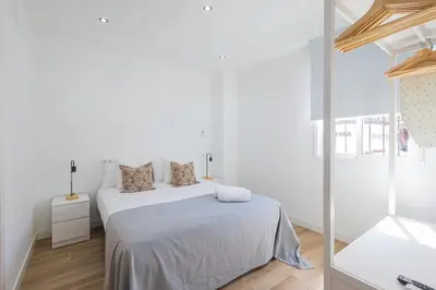 a white bedroom with a bed and a mirror at GuestReady - Inviting Valencia retreat in Valencia